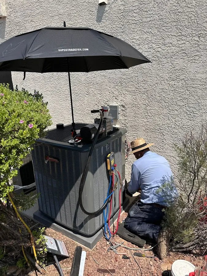 HVAC technician performing outdoor AC maintenance in Springville