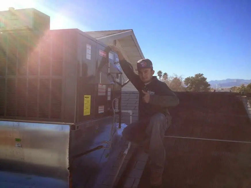 HVAC technician performing HVAC Inspection on a rooftop unit in Springville